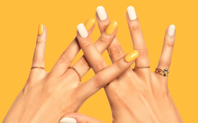 Imagen de las manos de una mujer con uñas postizas