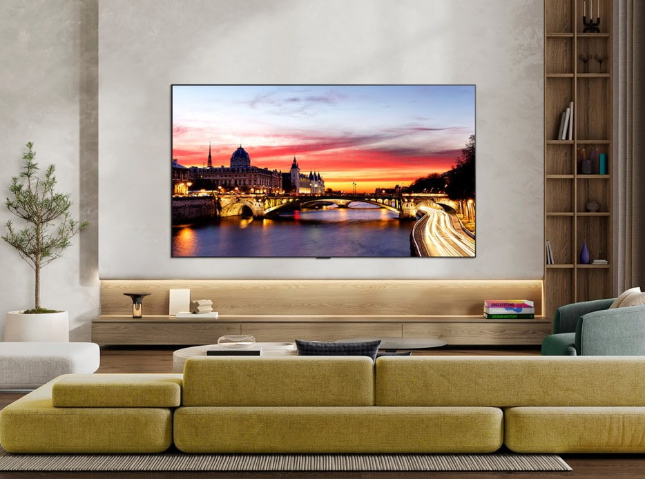 Televisor LG de gran formato mostrando una ciudad al atardecer en una sala moderna