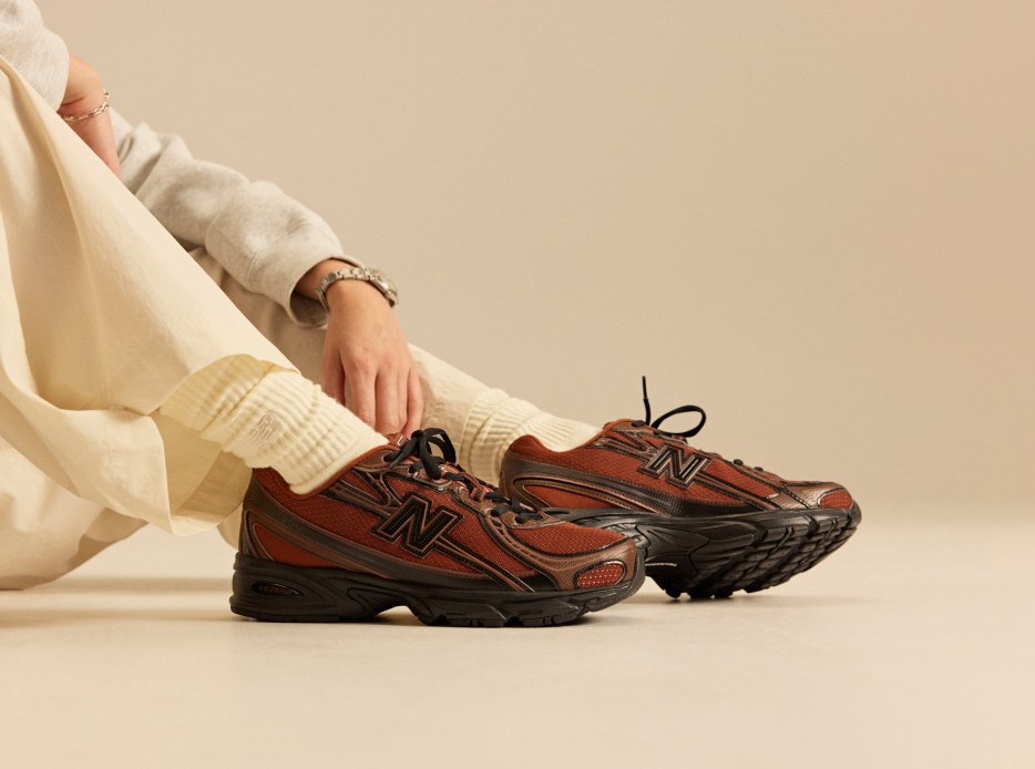 Imagen de los pies de un hombre usando tenis color rojos con negro 