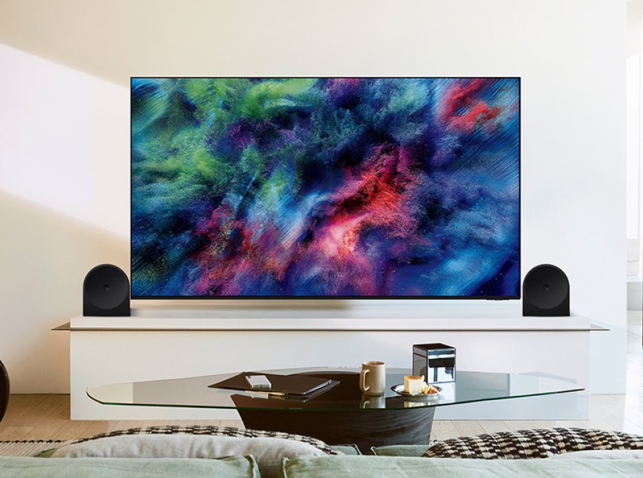 Pantalla Samsung con sistema de sonido y bocinas en una sala de estar moderna.