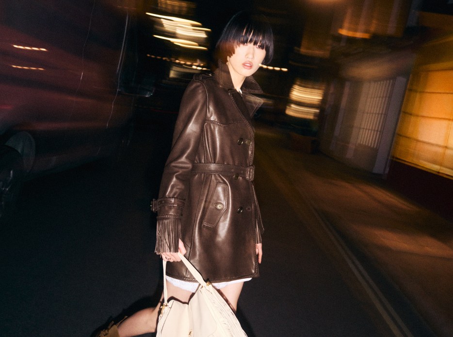 Mujer usando gabardina corta de piel color cafe BURBERRI