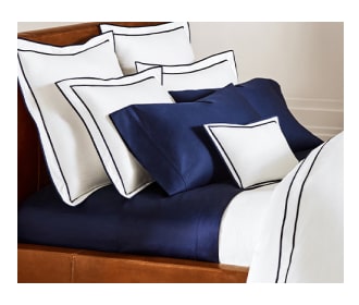Imagen de cama con colcha balnca con azul. POLO RALPH LAUREN