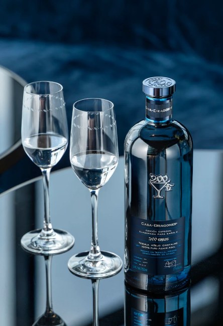 botella de tequila de CASA DRAGONES junto a dos copas