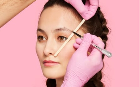 Imagen de una mujer a quien le estan haciendo servicio de cejas