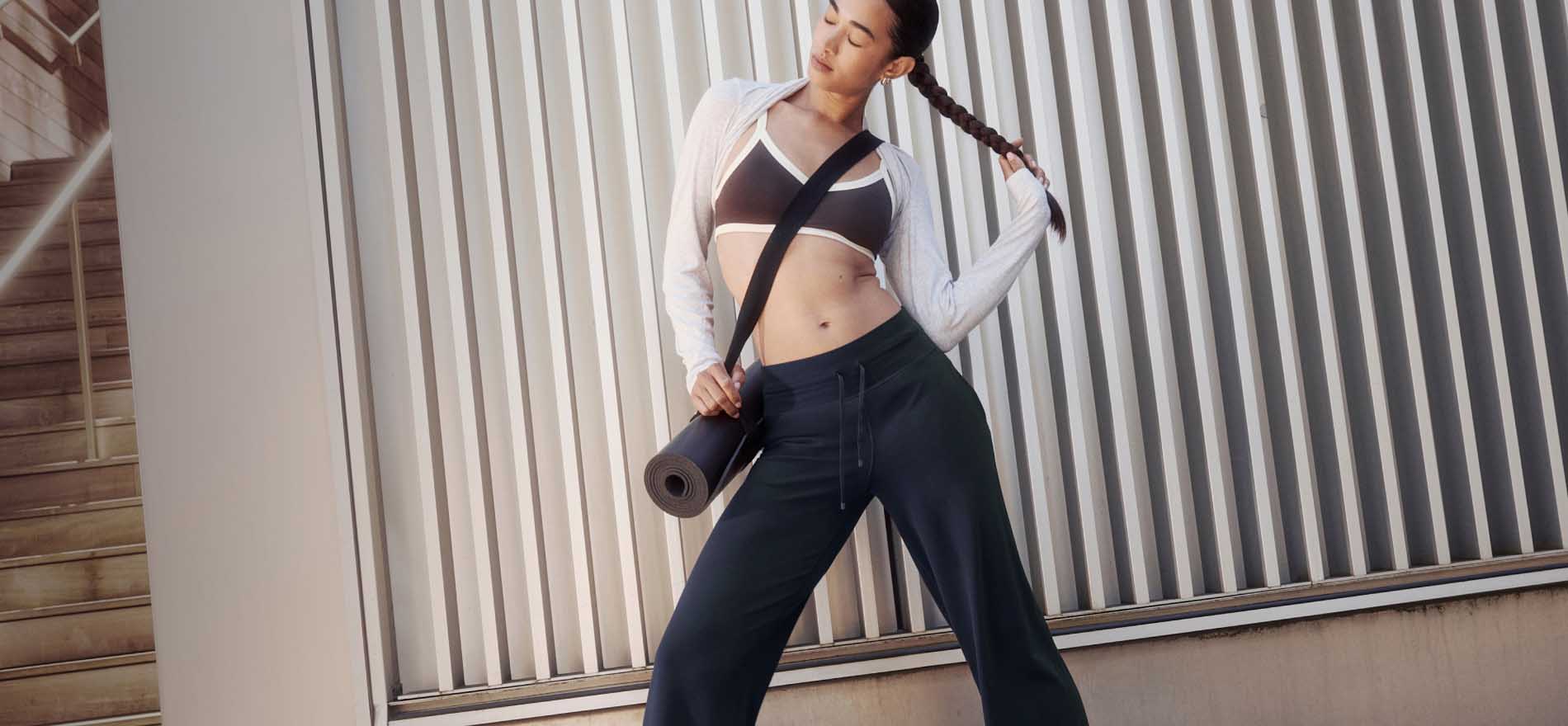 Imagen de una mujer bailando con chamarra blanca, top cafe y pantalon negro