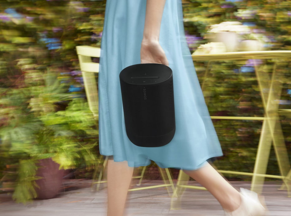 Mujer llevando una bocina color negra de la marca SONOS