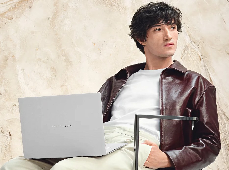Joven usando una computadora laptop ASUS plateada