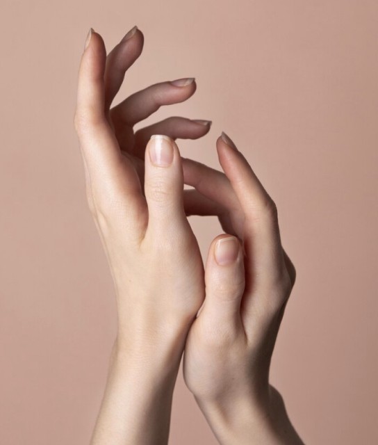 Imagen de dos manos con anillos y uñas postizas