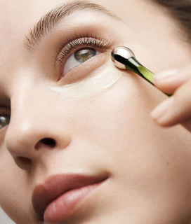 Rostro de una mujer, la cual se aplica crema LAMER en el parpado bajo 