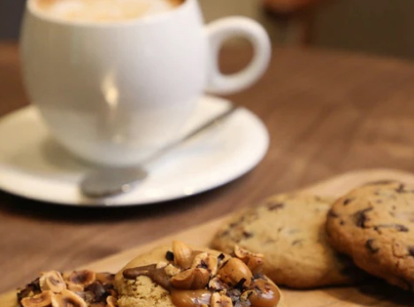 imagen de taza de café acompañada con galletas