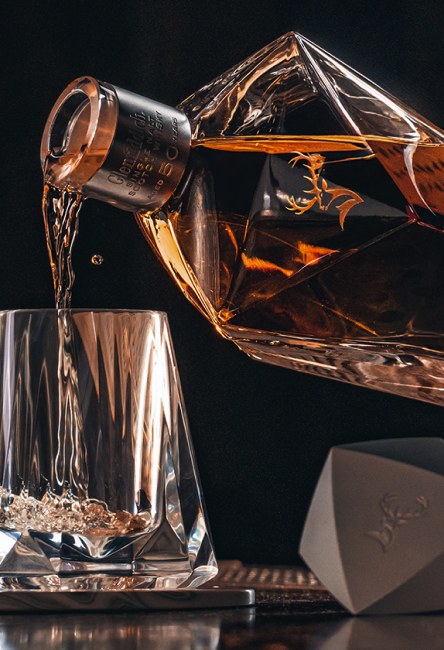 Imagen de persona sirviendo un vaso de Whisky GLENFIDDICH