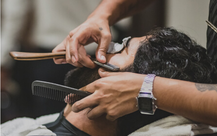 Imagen de un hombre al cual le hacen servicio de barberia