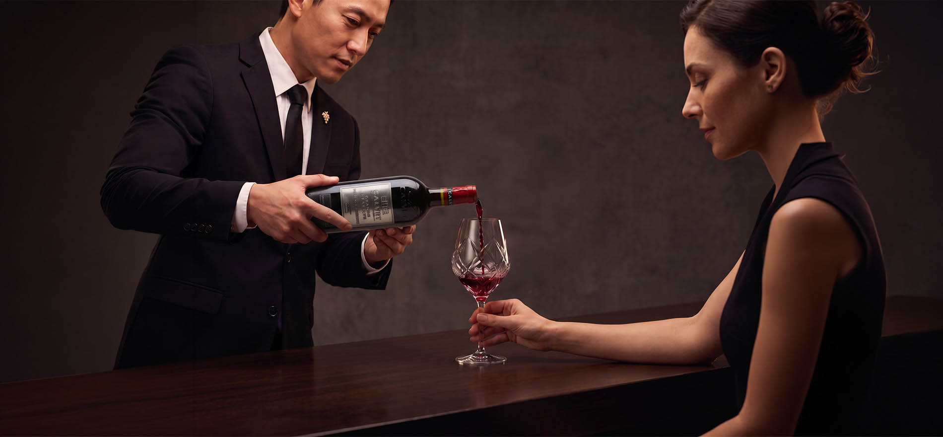 Imagen de un hombres sirviendo vino en una copa a una mujer