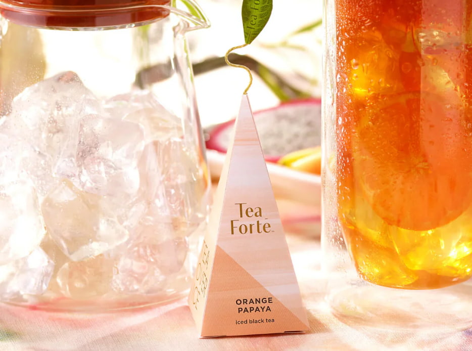 Imagen d eun empaque de té y una jarra con té TEA FORTE