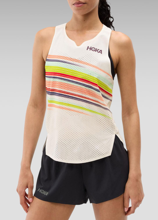 Mujer con playera sin mangas blanca con rayas de colores y short negro HOKA