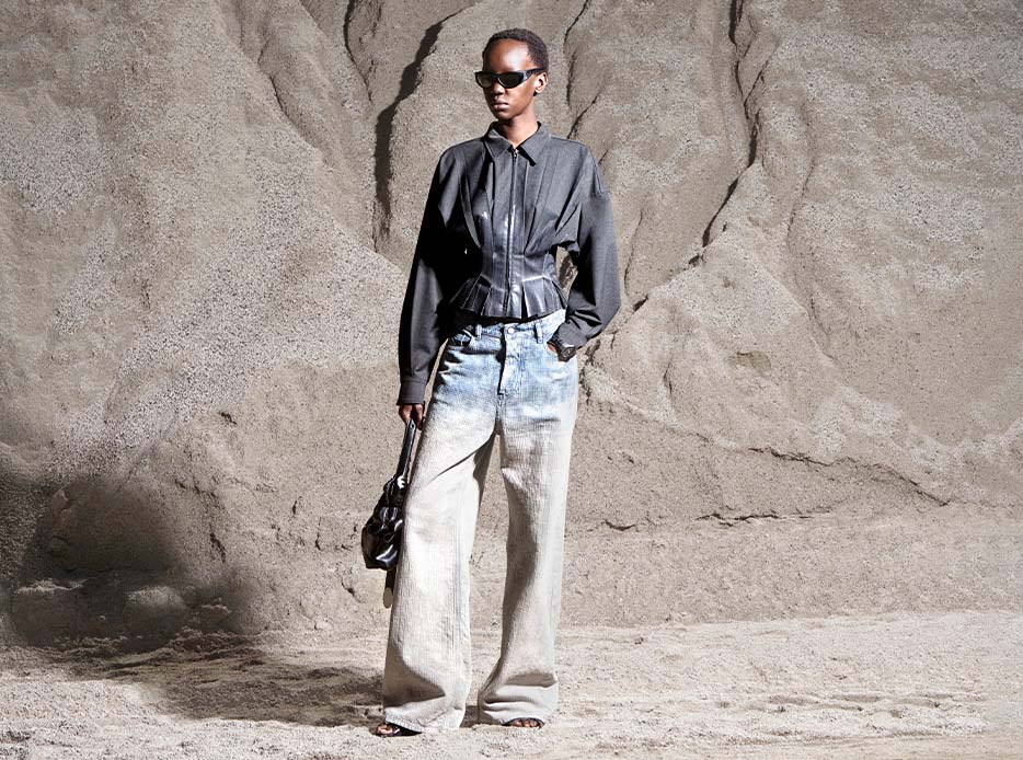 Imagen una mujer usando chamarra gris y pantalon de mezclilla