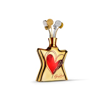 botella de locion en forma de estrella en color dorado con un corazon rojo en el centro de la botella