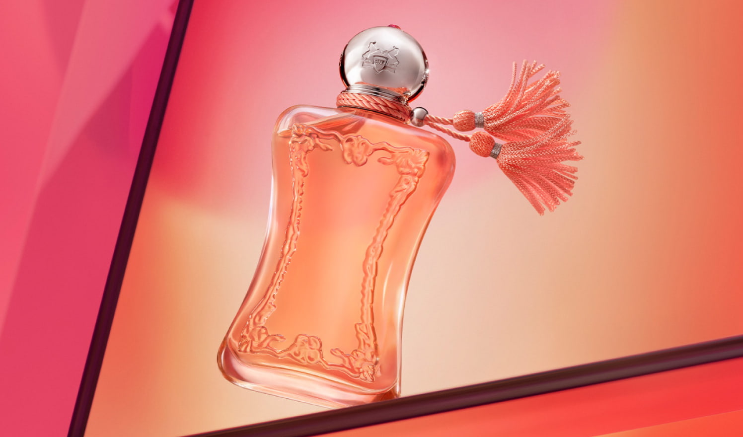 Perfume Ath&eacute;na&iuml;s de Parfums de Marly sobre un fondo rosa y naranja