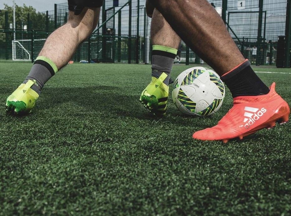 hombre practicando futbol con tenis rojos y verdes