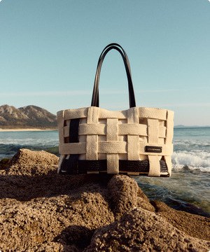 Imagen se un bolso beige de marca ADOLFO DOMÍNGUEZ, banner menu