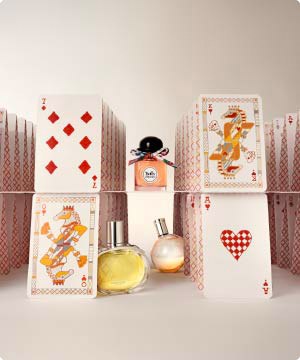 ymagen de unas cartas de baraja y dos frascos de perfume HERMÈS menu