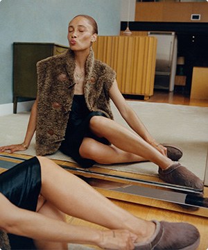 Imagen de una mujer fente a un espejo usando una pantunflas de la marca UGG, banner menu
