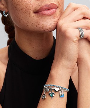 Imagen de una mujer con pulseras de la marca PANDORA, banner menu