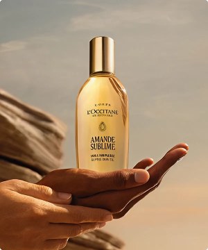 Hombre acostado en una cama, junto a el 4 envaces de perfume  de perfume L'OCCITANE menu