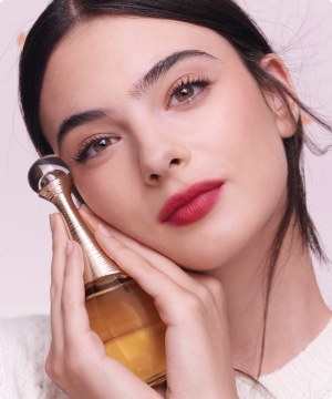 Mujer sosteniendo un frasco de perfume DIOR menu