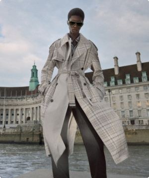 imagen de una mujer usando una gabardina gris a cuadros de la marca BURBERRY 