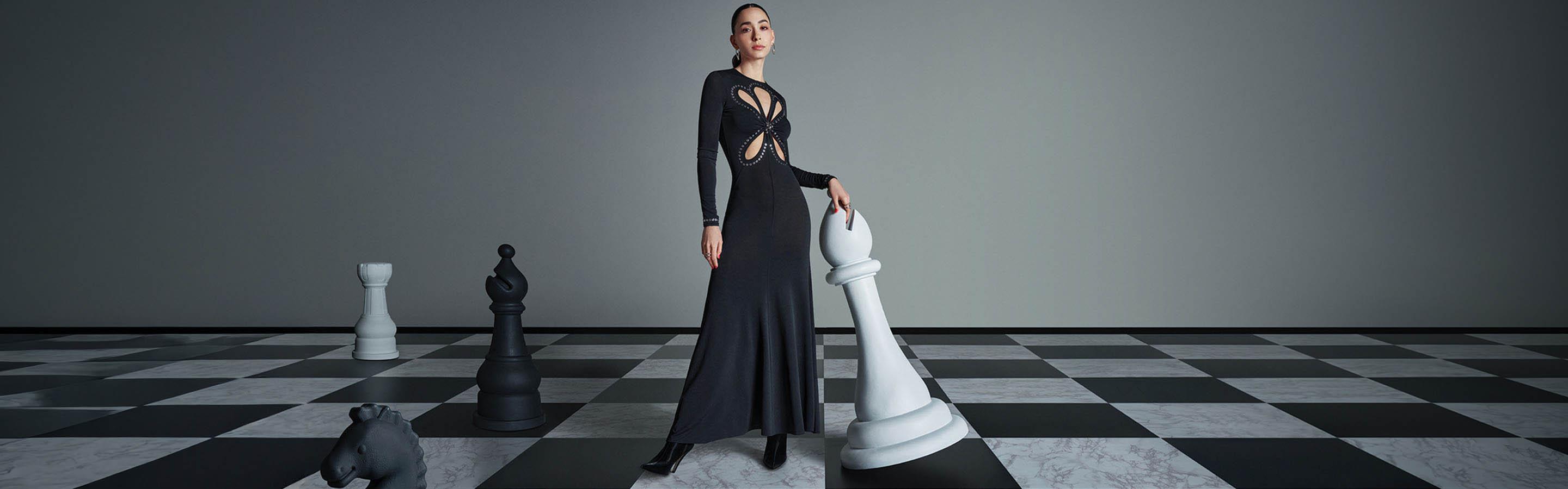 Oportunidades Únicas, Imagen de un hombre y una mujer con ropa negra, se encuentran parados sobre un tablero de ajedrez, hasta 40% de descuento + 3 mensualidades sin intereses + envio gratis de diciembre 25 a enero 22 