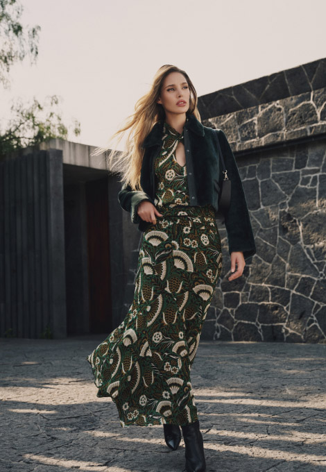 mujer con chamara negra de piel y vestido verde con detalles blancos