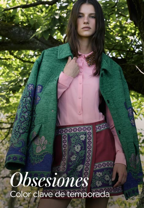 Imagen de una mujer, usando blusa rosa, falda color vino con estampdo fe flores y un saco color verde