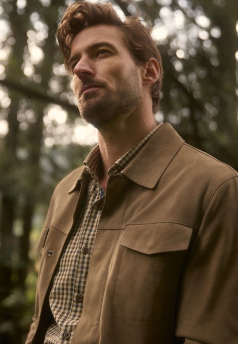 Imagen de un hombre, usando una chamarra color marron