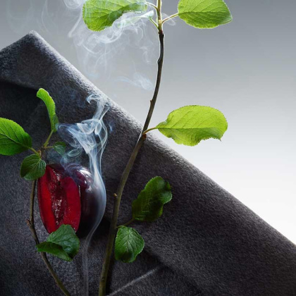 Imagen de una ciruela roja la cual parece quemarce y saca humo