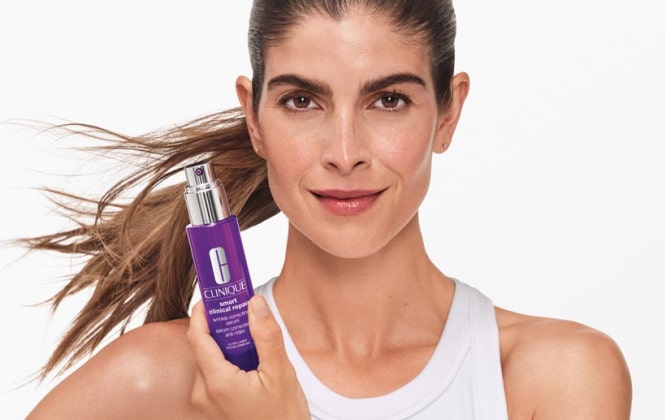 Mujer sosteniendo frasco de smart repair de CLINIQUE
