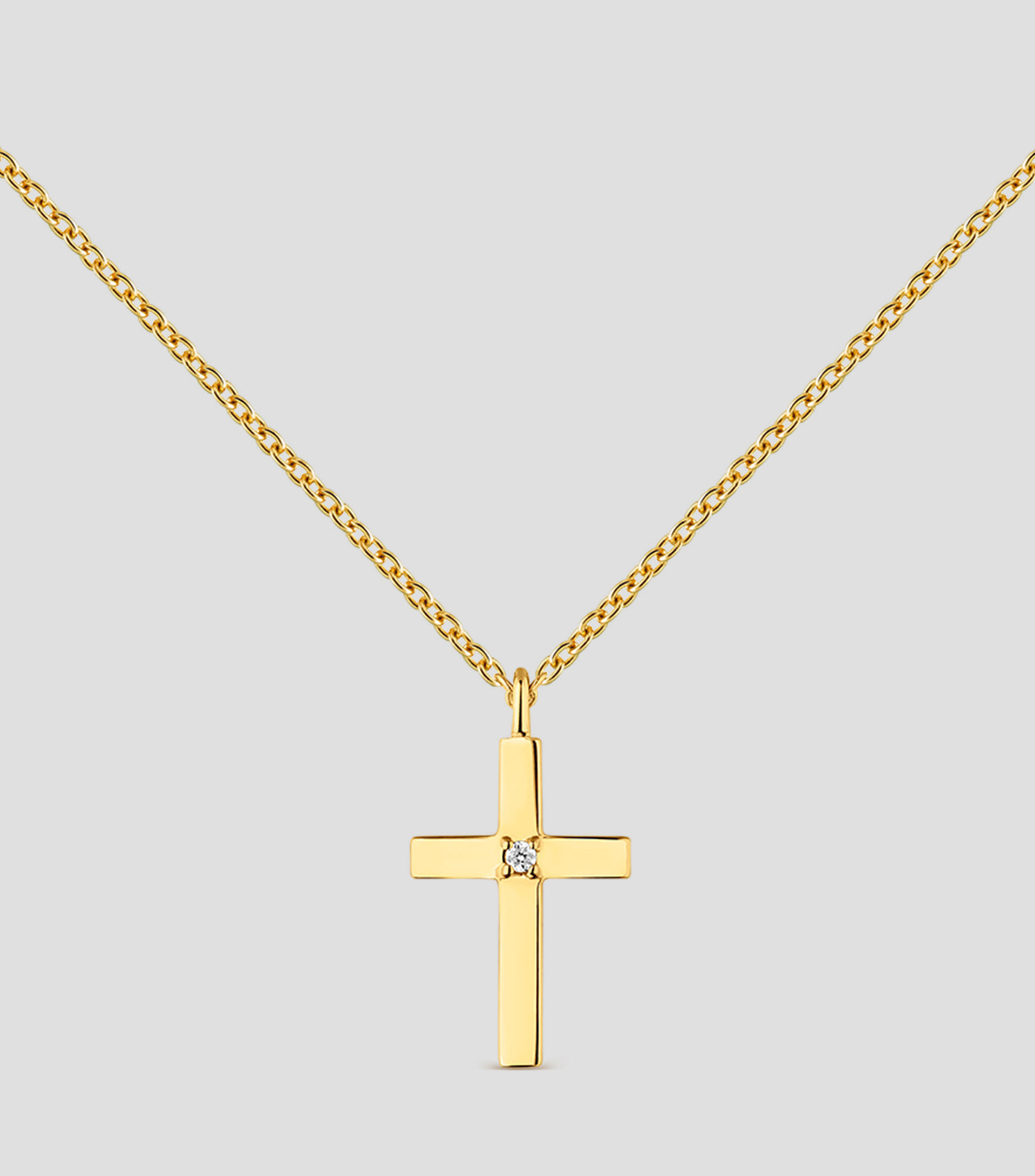 Colgante de oro amarillo de 18K con cruz mediana y diamante en talla brillante de 0,01 cts