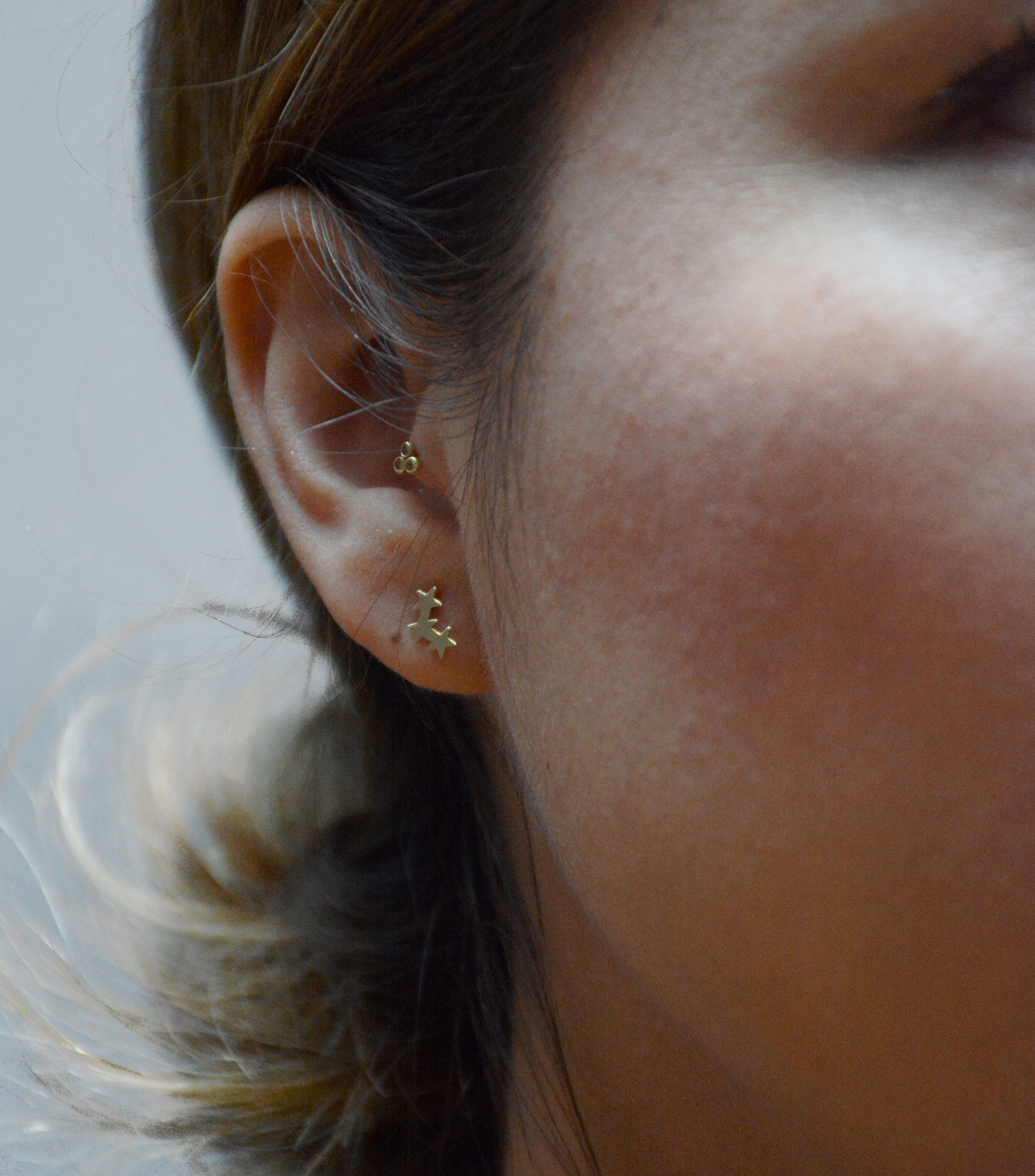 Aretes en oro amarillo de 10 kilates con tres estrellas en fila Niña