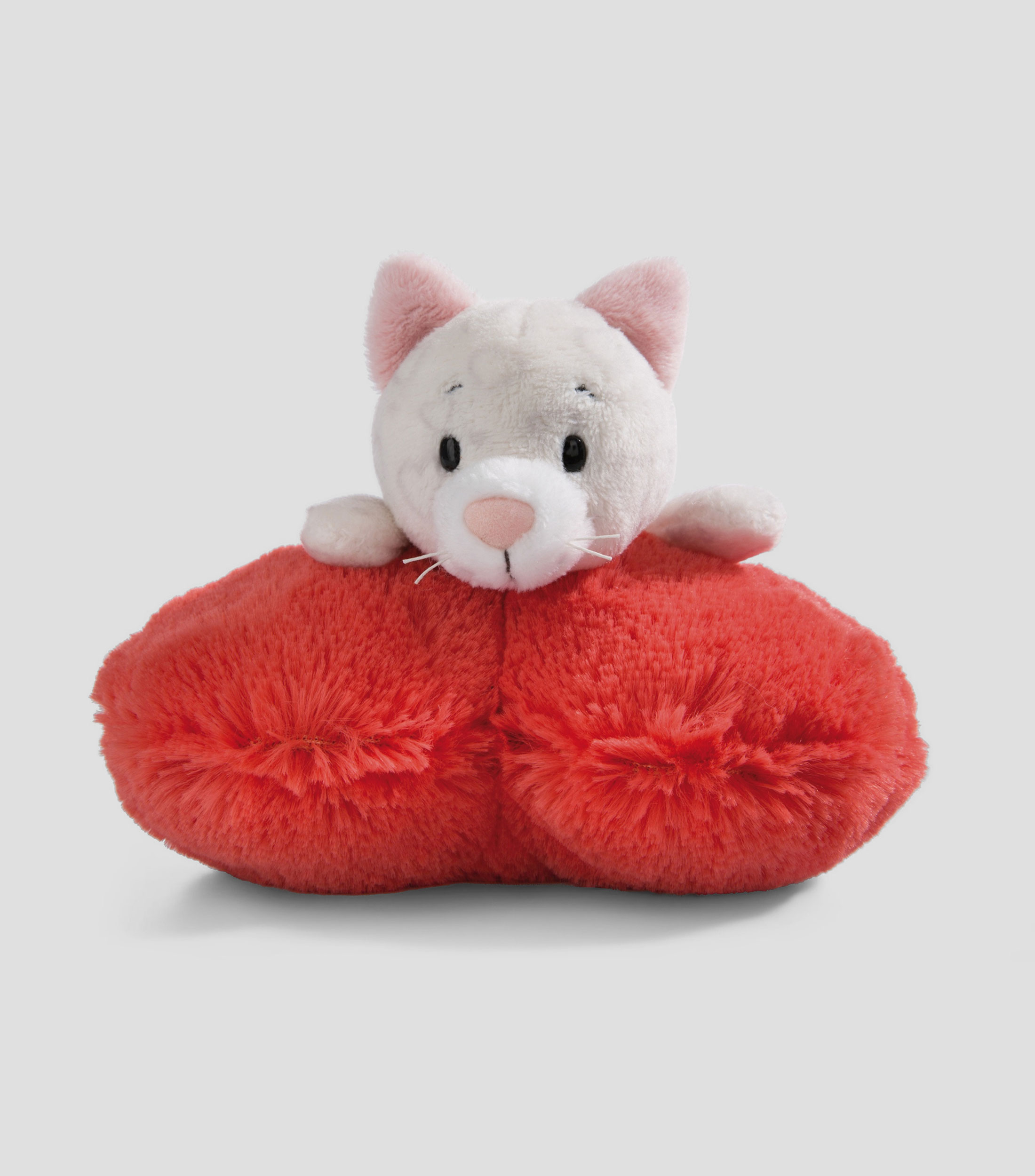 Gato de peluche acostado en corazón