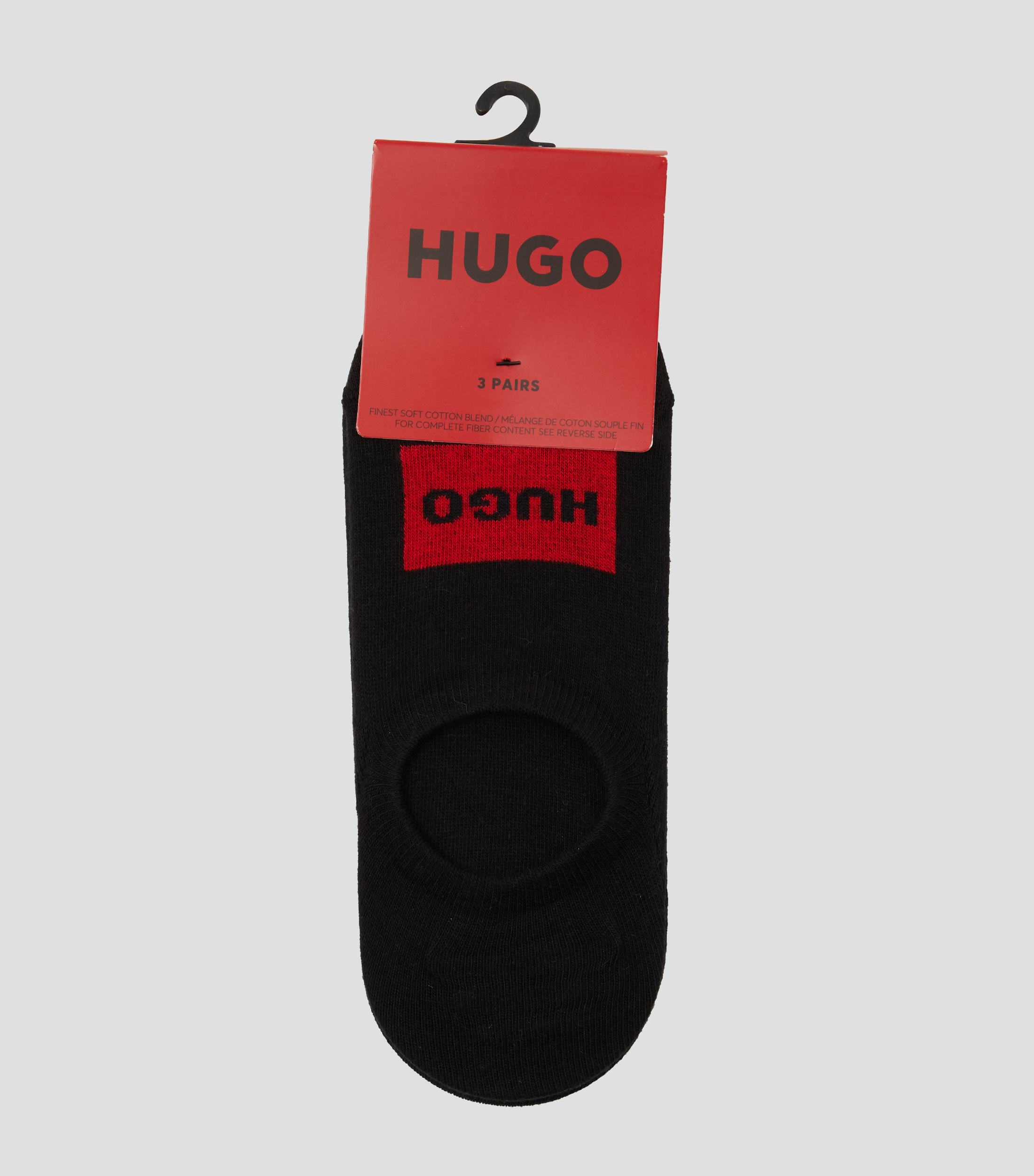 Un set de tres pares de calcetines invisibles con etiquetas con logo rojas Hombre
