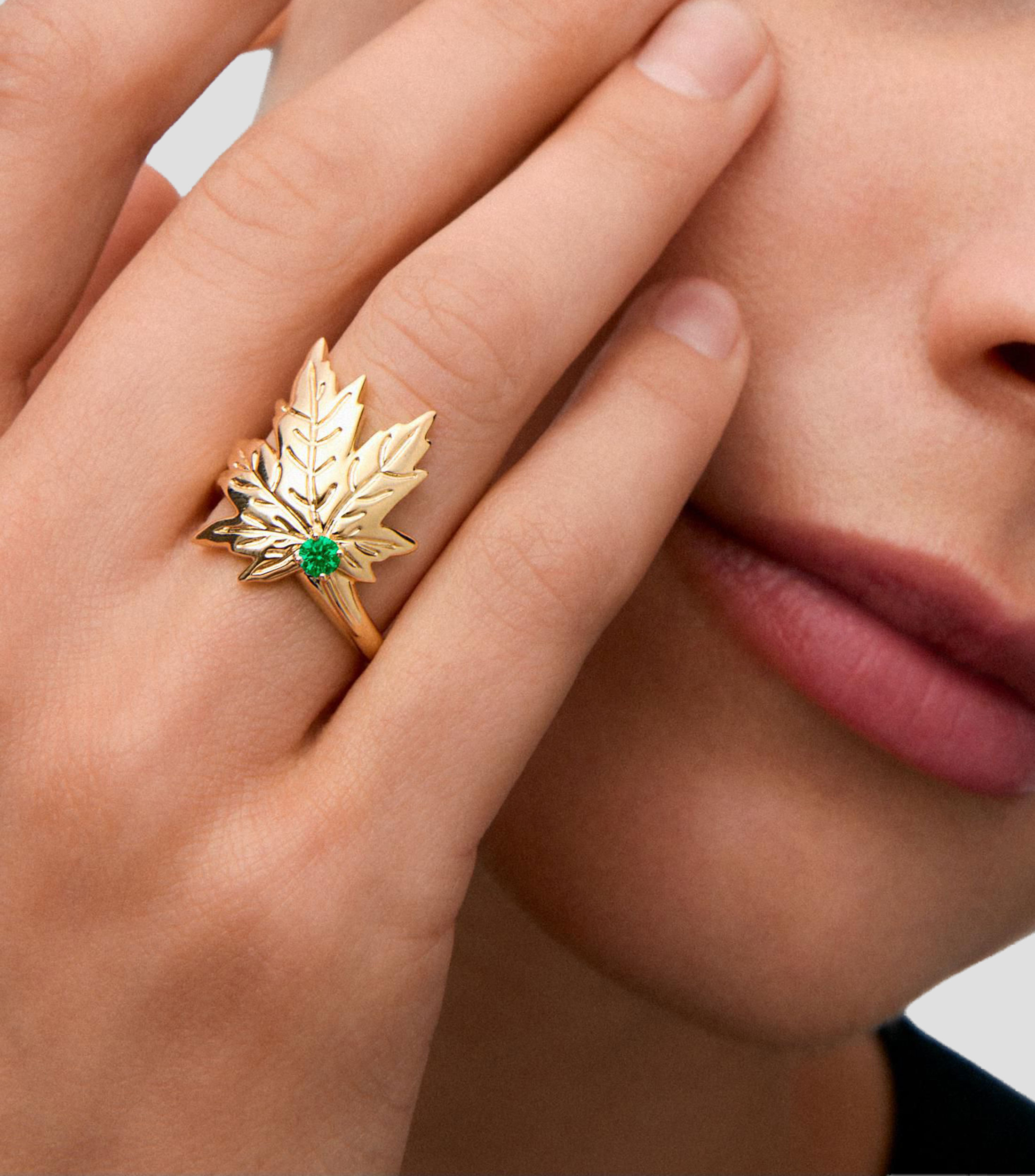 Anillo en Oro amarillo de 18 Kilates con esmeralda central en talla brillante y forma en hoja de arce Mujer