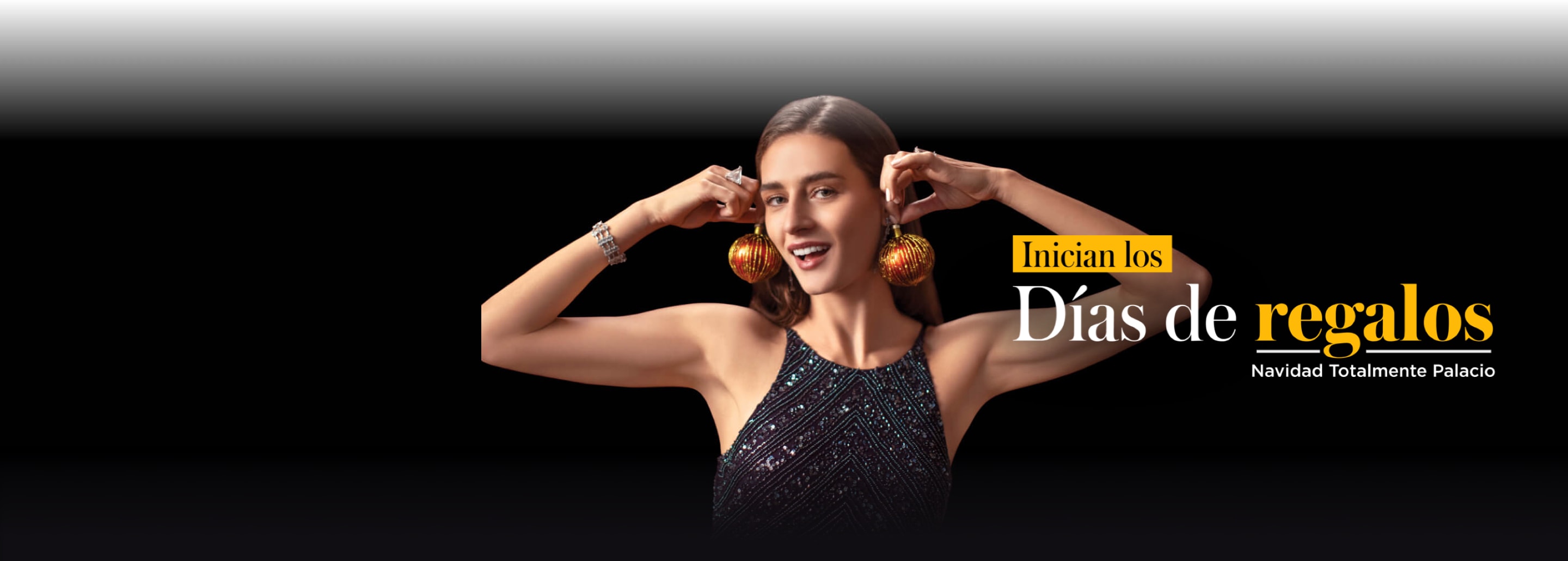 Mujer usando un vestido de noche negro con brillantes. Sostiene un par de esferas navideñas de color rojo junto a sus orejas, como si fueran un par de aretes. Gourmet