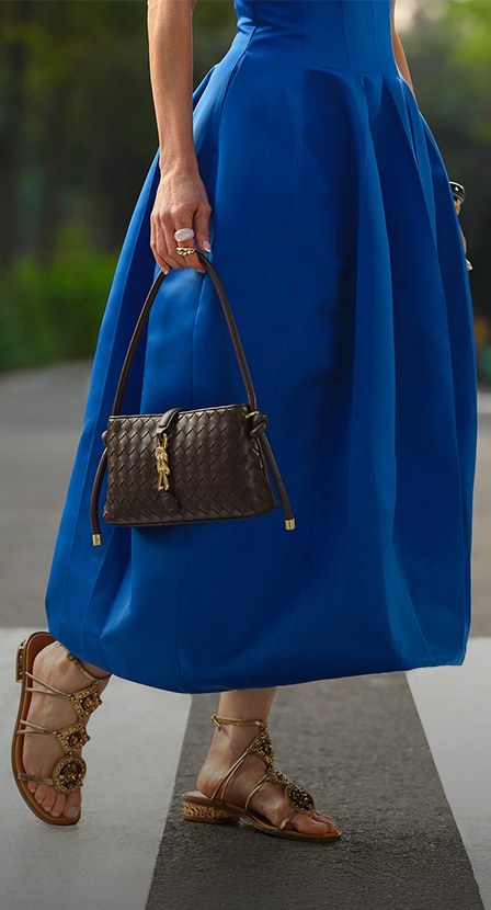 imagen de mujer con vestido azul y bolso negro de mano