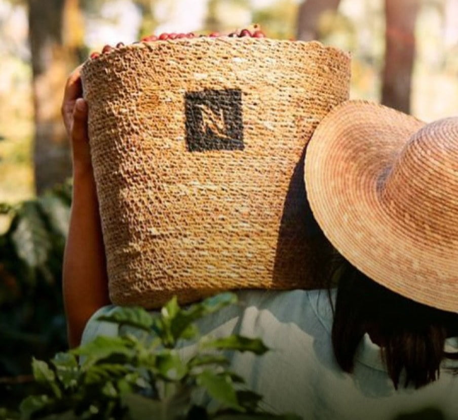 Imagen de una mujer cargando una canasta con granos de cafe, NESPRESSO