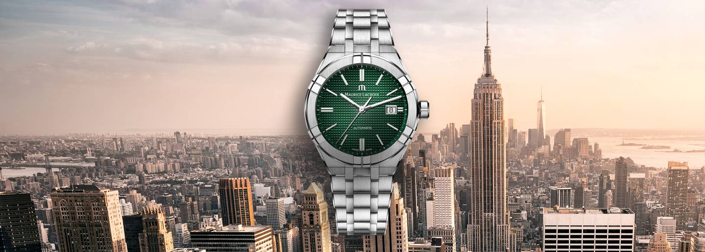 Imgen de un reloj de la marca MAURICE LACROIX, color plateado con caratula verde, de fondo la imagen de una ciudad con edificios. MAURICE LACROIX
