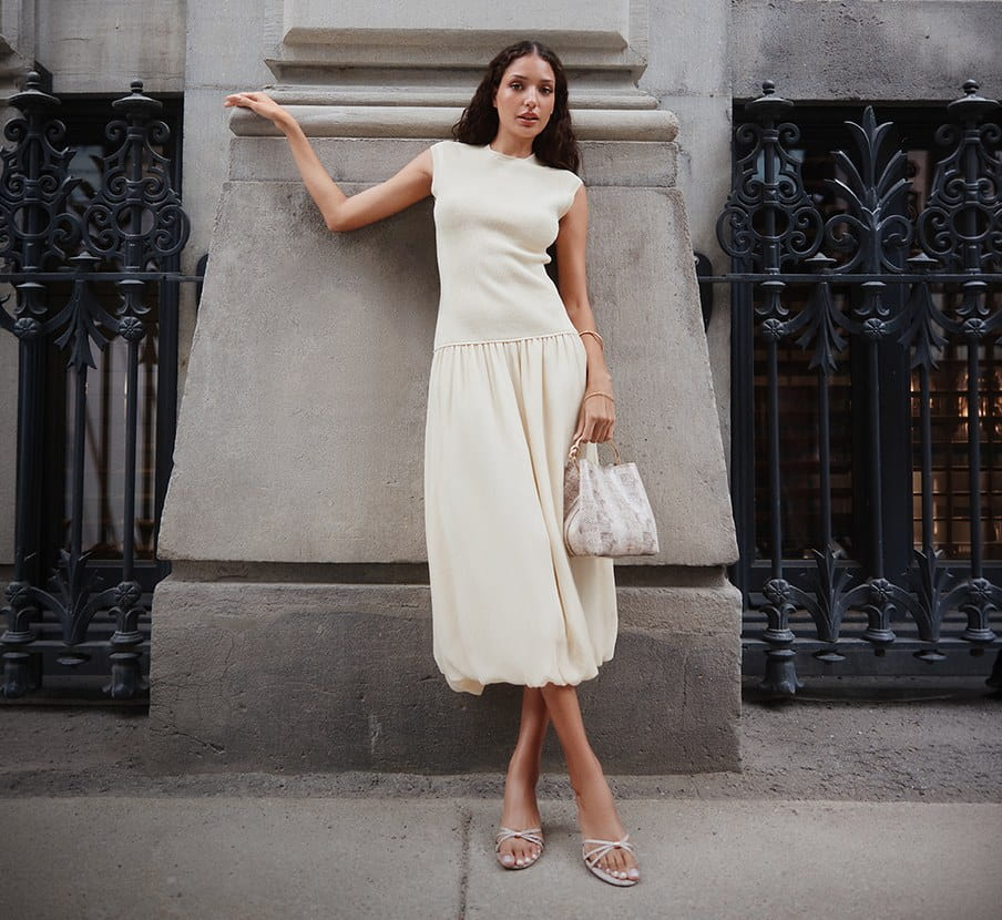 imagen de mujer con vestido y bolso blanco de la marca ALDO