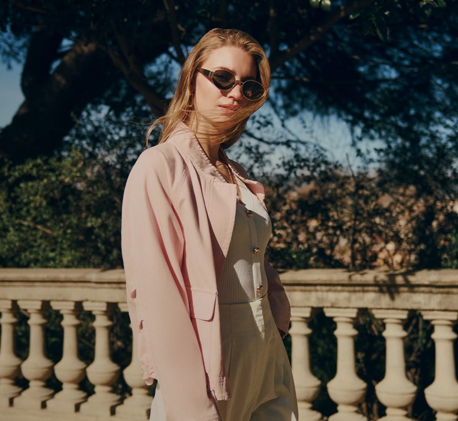 Imagen de mujer con saco cafe y lentes de sol de la marca JULIO