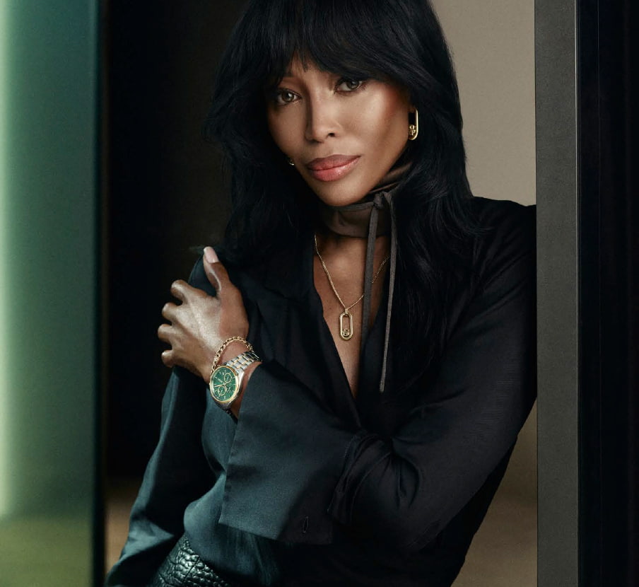 imagen de mujer con ropa negra y reloj plateado con caratula verde de la marca BOSS