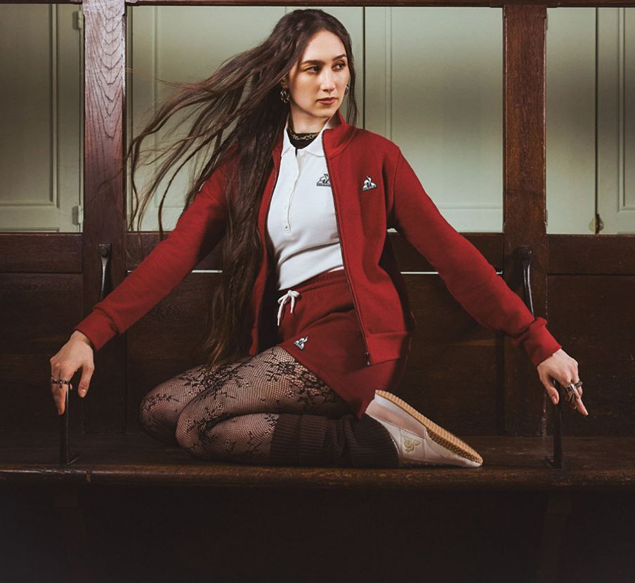 Imagen de un mujer con traje rojo de la marca LE-COQ-SPORTIF