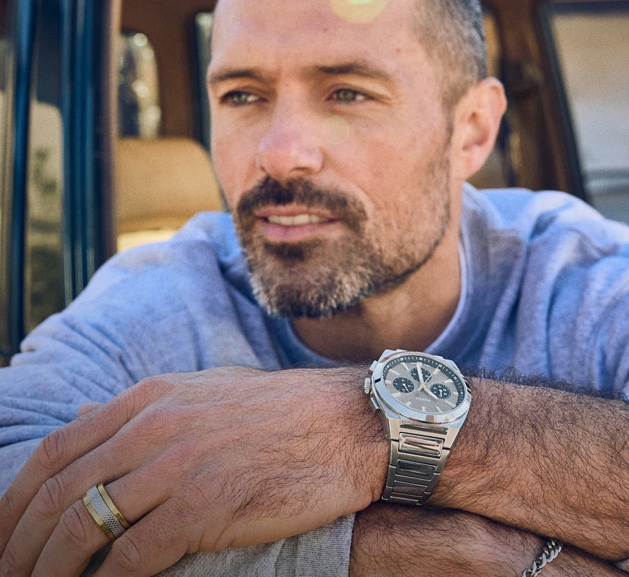 imagen de hombre con camisa azul y reloj gris de la marca FOSSIL